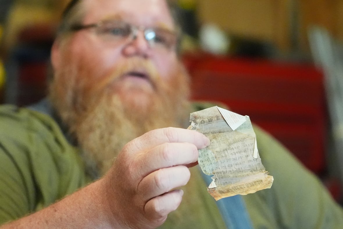 Richard Guilford holds up a lottery ticket he purchased 11 years ago during an interview Thursday, Aug. 14, 2025, in Petersburg, Mich. 