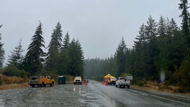 A road closed off by yellow trucks