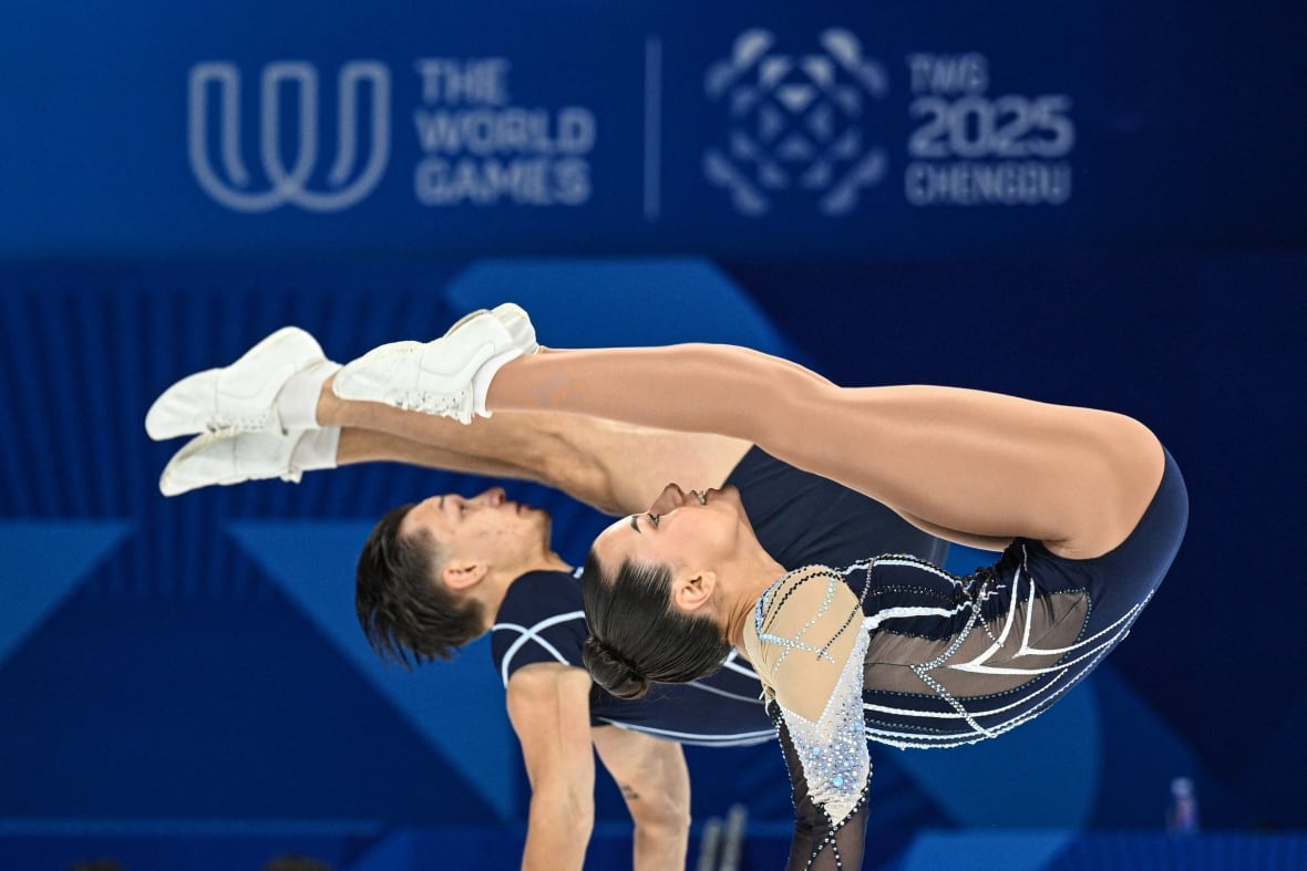 Two athletes competing and performing on a gymnasium floor.