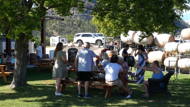 People sit at a an outdoor table at a the Lightning Rock winery in Summerland.