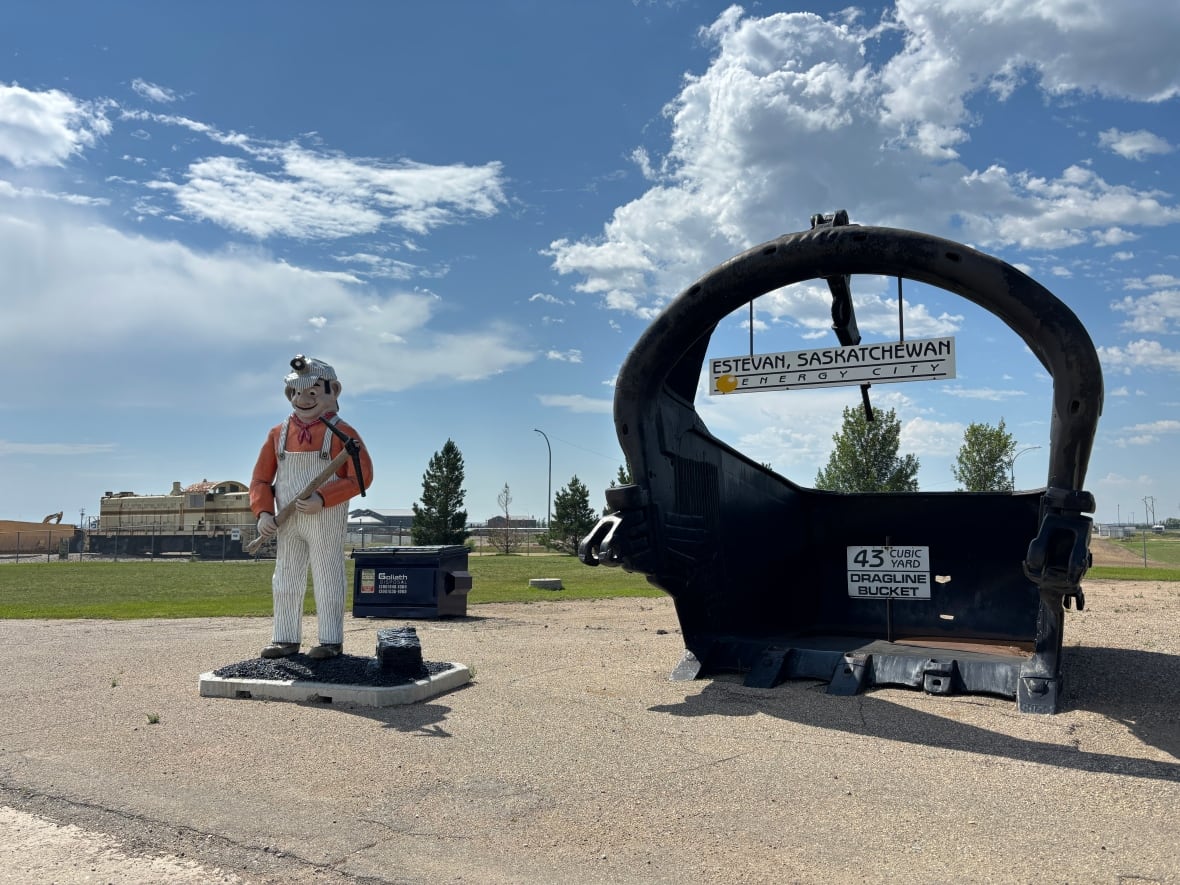 Coal miner station next to large coal drag bucket with Estevan, Saskatchewan sign