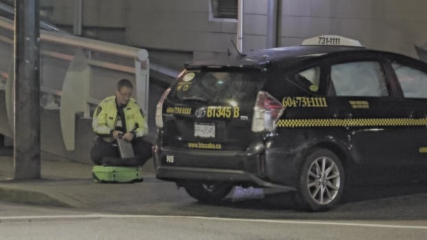 A police officer crouches by a black taxi cab, with another white car visible to his right.