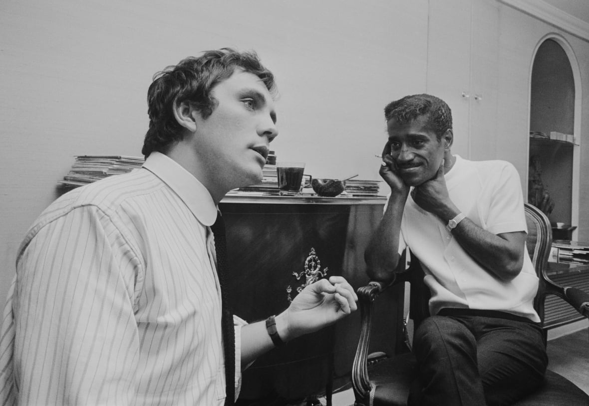 Two people have a conversation in this black and white image.