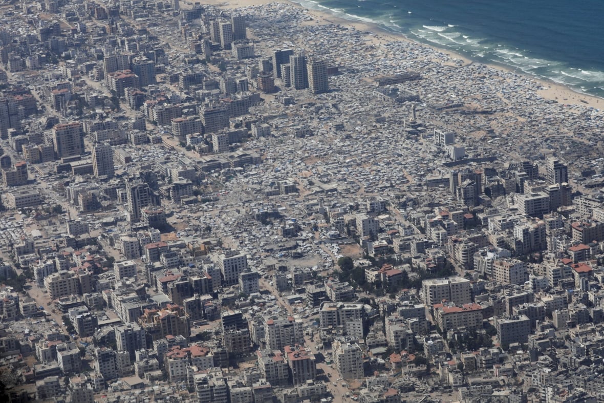 An aerial view shows a city heavily damaged by bombing.