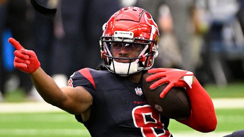 A men's football player reacts after a catch.