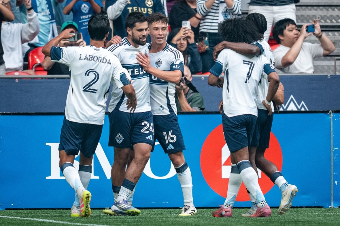 Vancouver Whitecaps' Brian White (24) celebrates his goal against the Houston Dynamo with Mathias Laborda (2), Sebastian Berhalter (16) and Jayden Nelson (7) during the first half of an MLS soccer match.