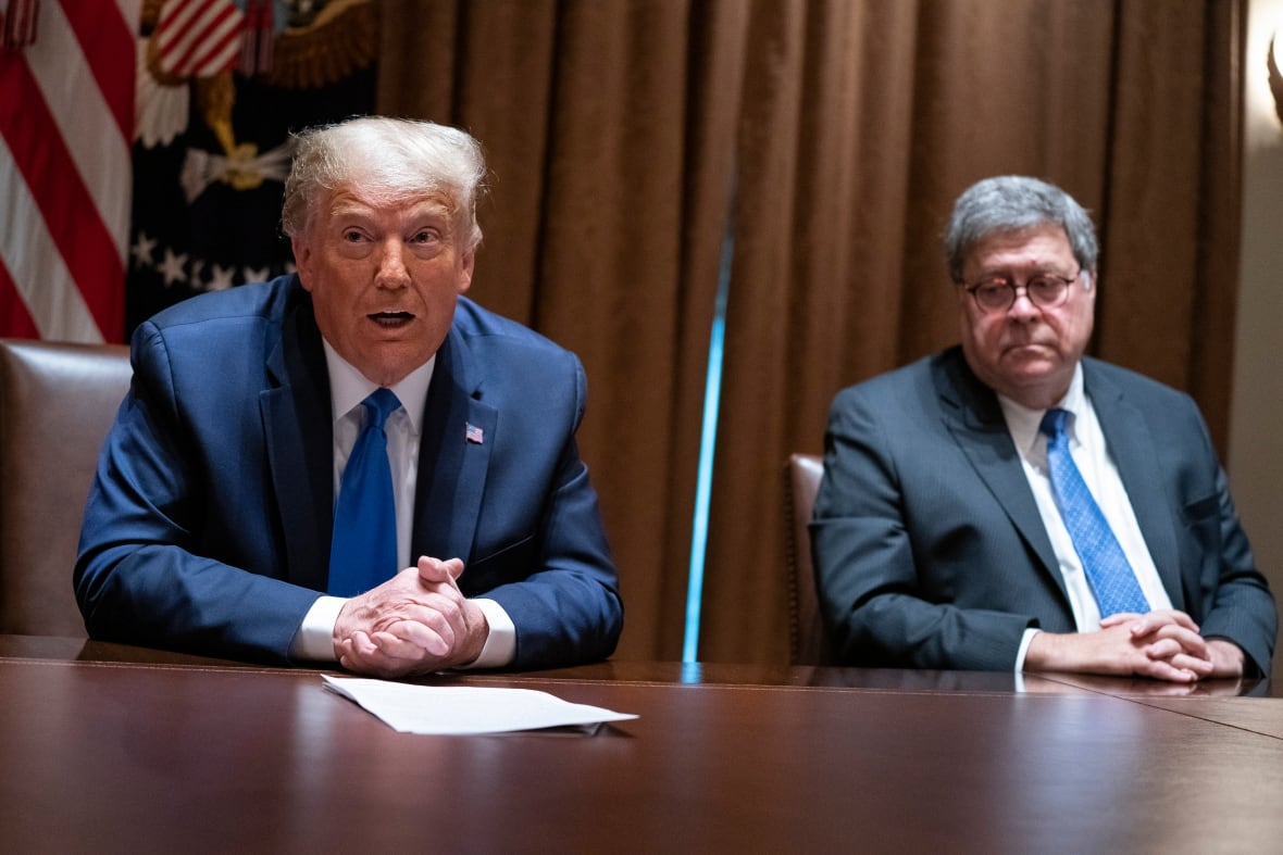 Two elderly men appear in a sitting on a table, wearing a suit and tie.