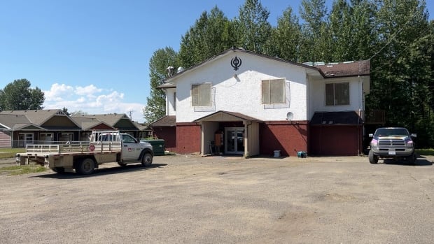 The former Gurdwara in Mackenzie B.C. will be known as the Herb Singh building. Trucks parked outside of the former Mackenzie Gurdwara as men work on the building's roof.