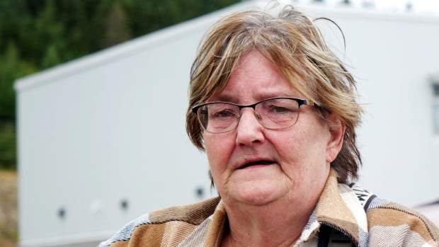 A woman wearing glasses and a plaid jacket.