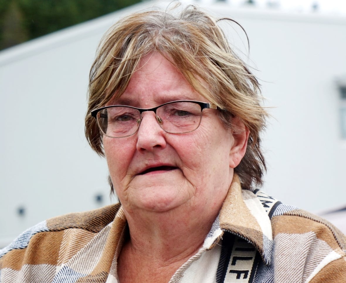 A woman wearing glasses and a plaid jacket.