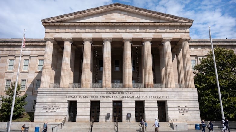 A large building with people in front.