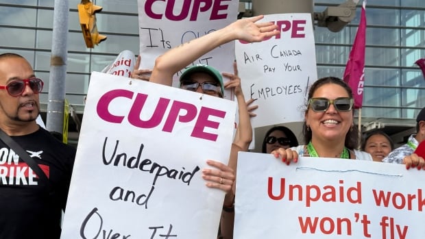 Workers hold signs saying "unpaid work won't fly."