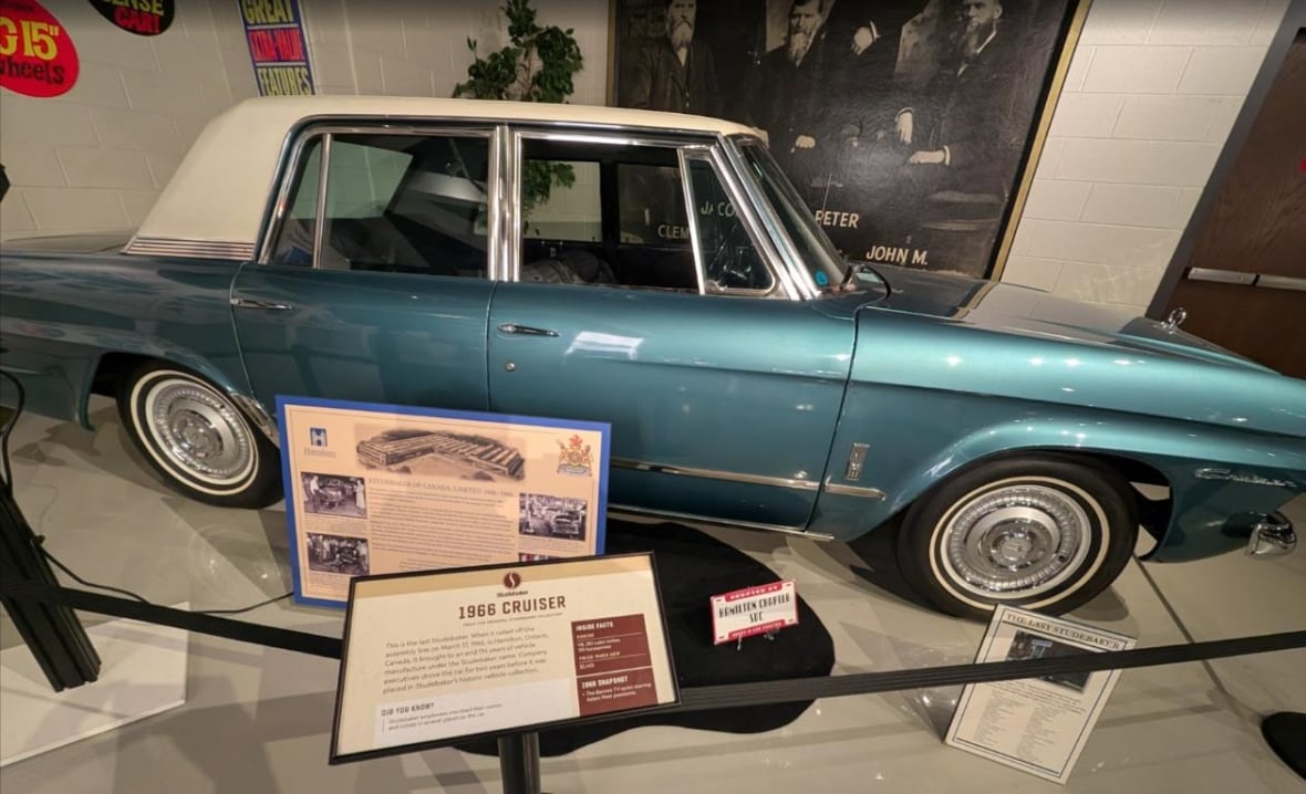 A car on display in a museum roped off and with a display in front of it.