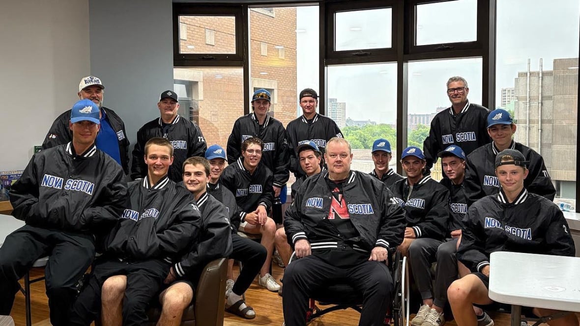 A softball team is seen posing for a group photo in a hospital.