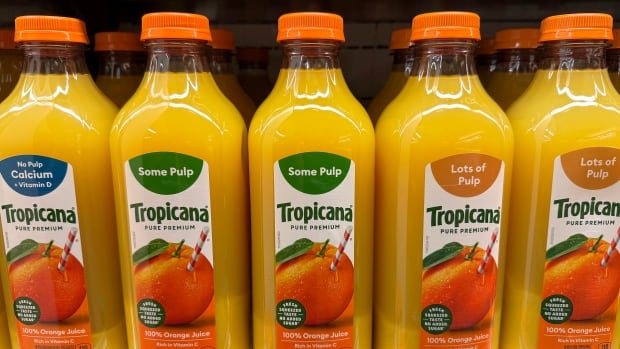 Containers of Tropicana orange juice are displayed on a grocery store shelf 