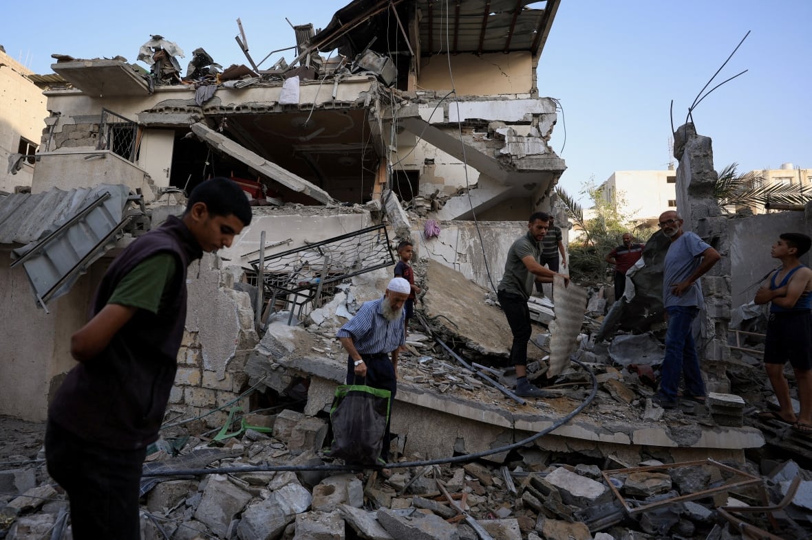 People are inspecting a house that is bombed.