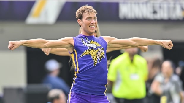 A male cheerleader with this arms extended