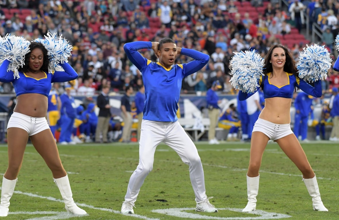 Three cheerleaders make the process in the football, one is male