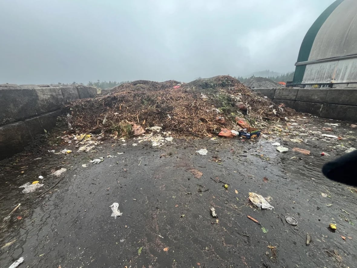 A brown pile of compost sits under a cloudy sky.