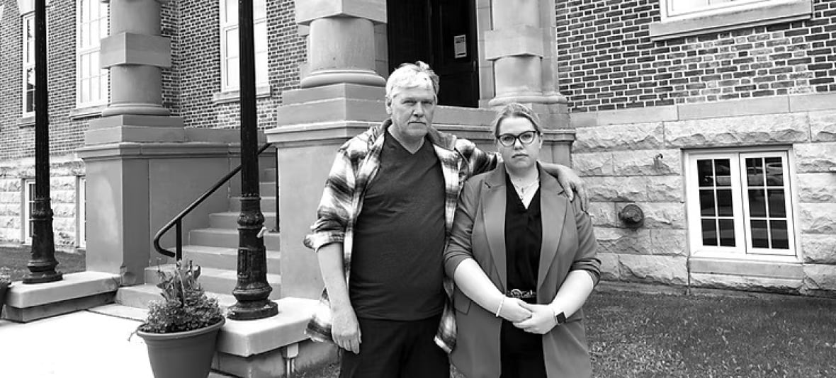 A man and woman stand outside a courthouse