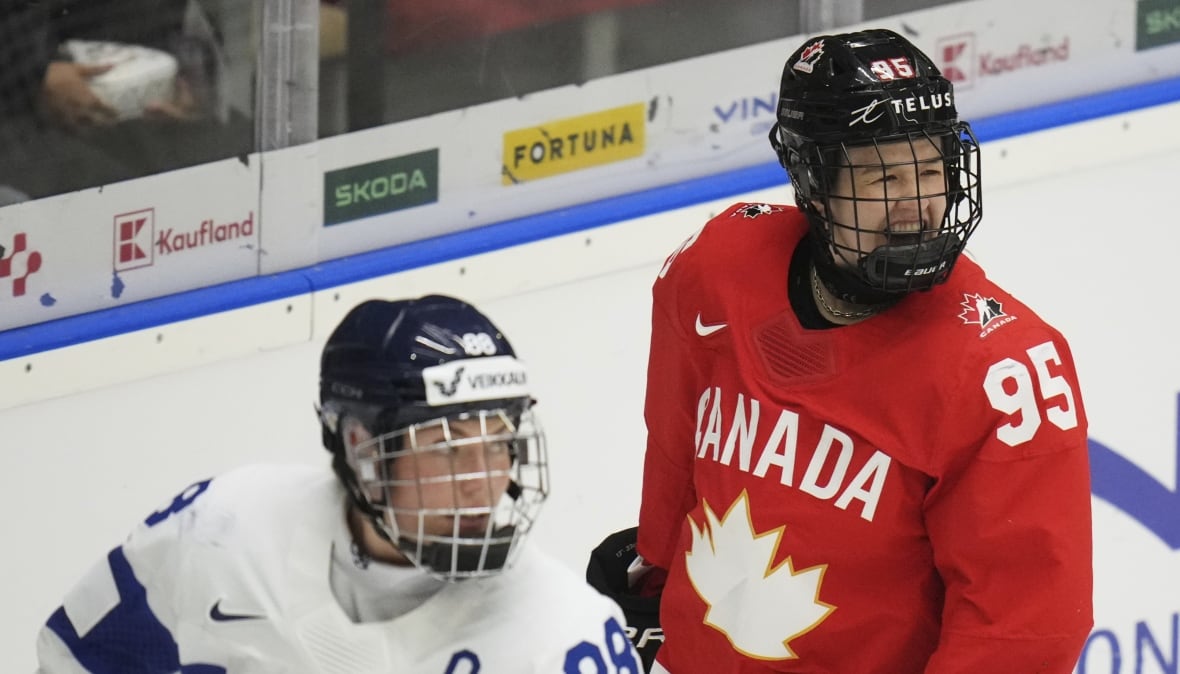 A Canadian hockey player smiles beside a Finnish hockey player.
