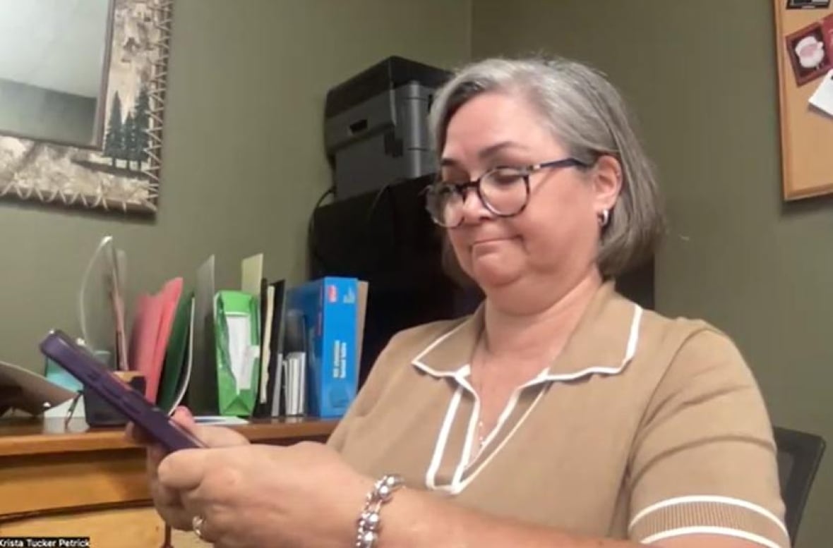 Krista Tucker holding a smartphone