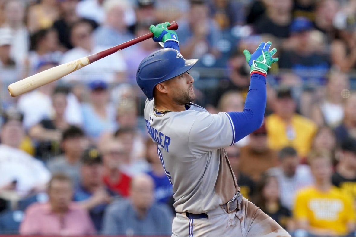 George Springer of the Toronto Blue Jays holds a bat in one hand after hitting a home run.
