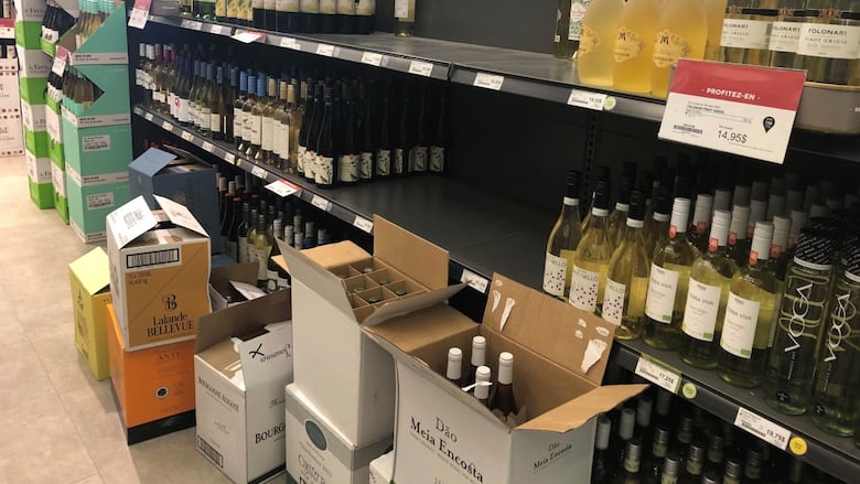 商店货架上和地板上的盒子里都摆满了酒瓶