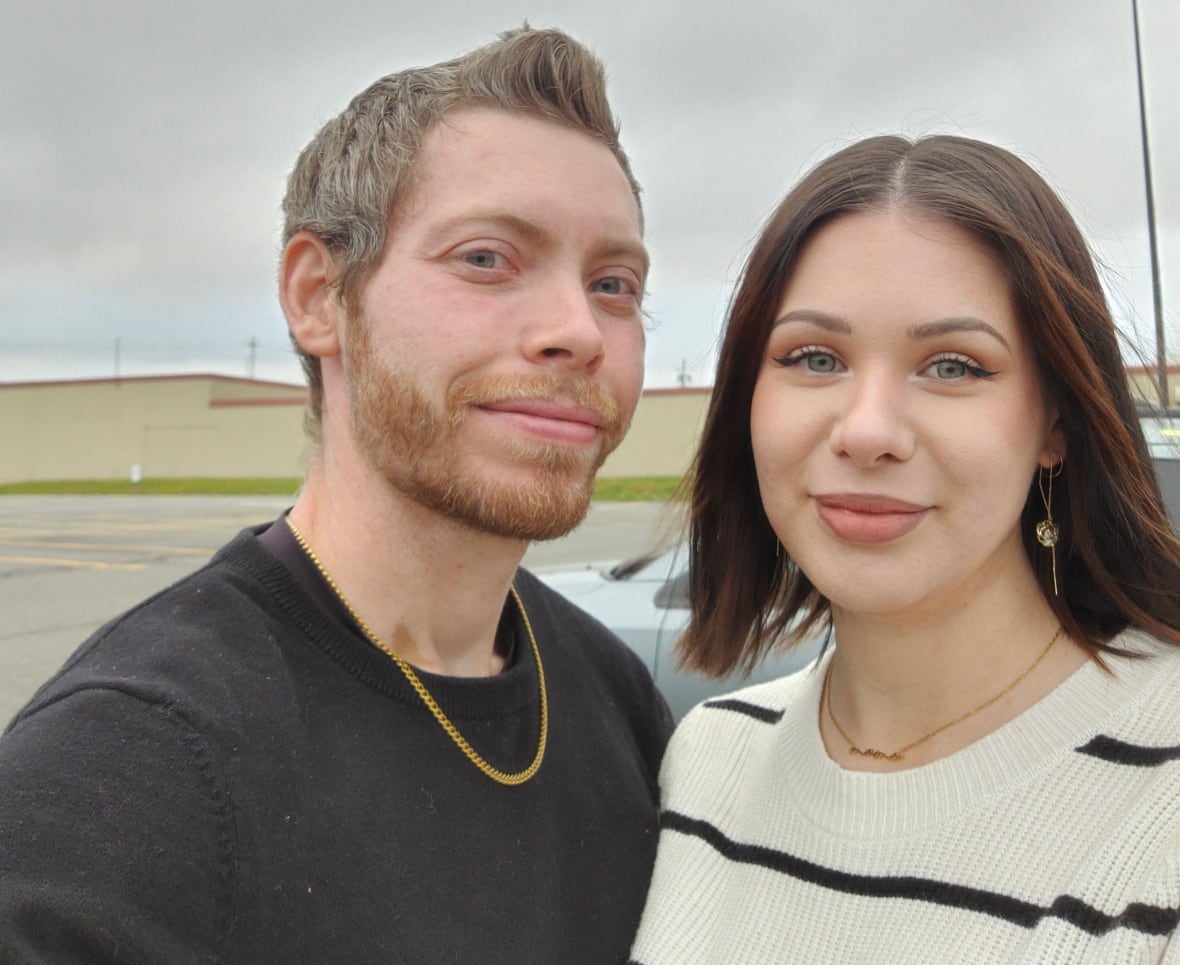 A man and woman pose for a selfie.