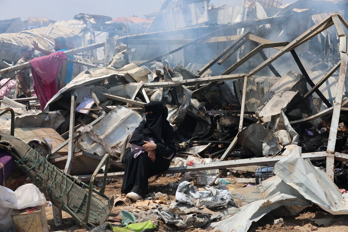 A woman sitting in a debris.