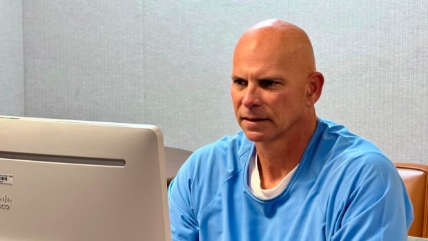 A person is seen seated at a computer.