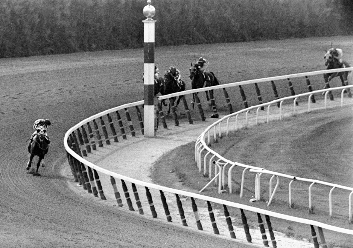A black and white picture from a horse race.