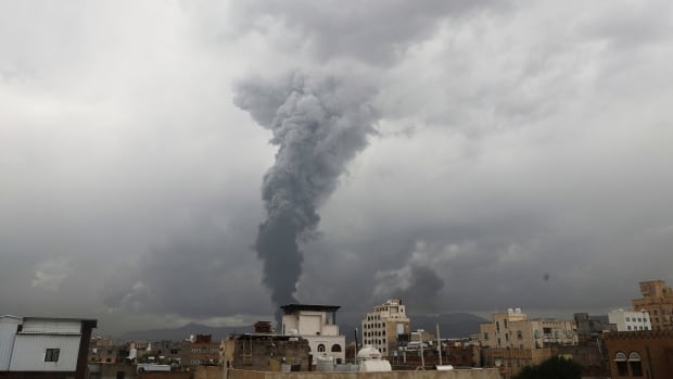 Smoke billows following Israeli airstrikes in multiple areas in Sanaa, Yemen, Sunday, Aug. 24, 2025. (AP Photo/Osamah Abdulrahman) A large plume of black smoke rises above a city.