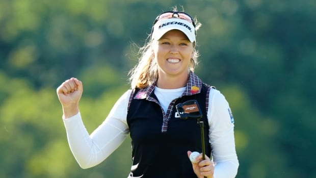 A women's golfer celebrates after winning a tournament.