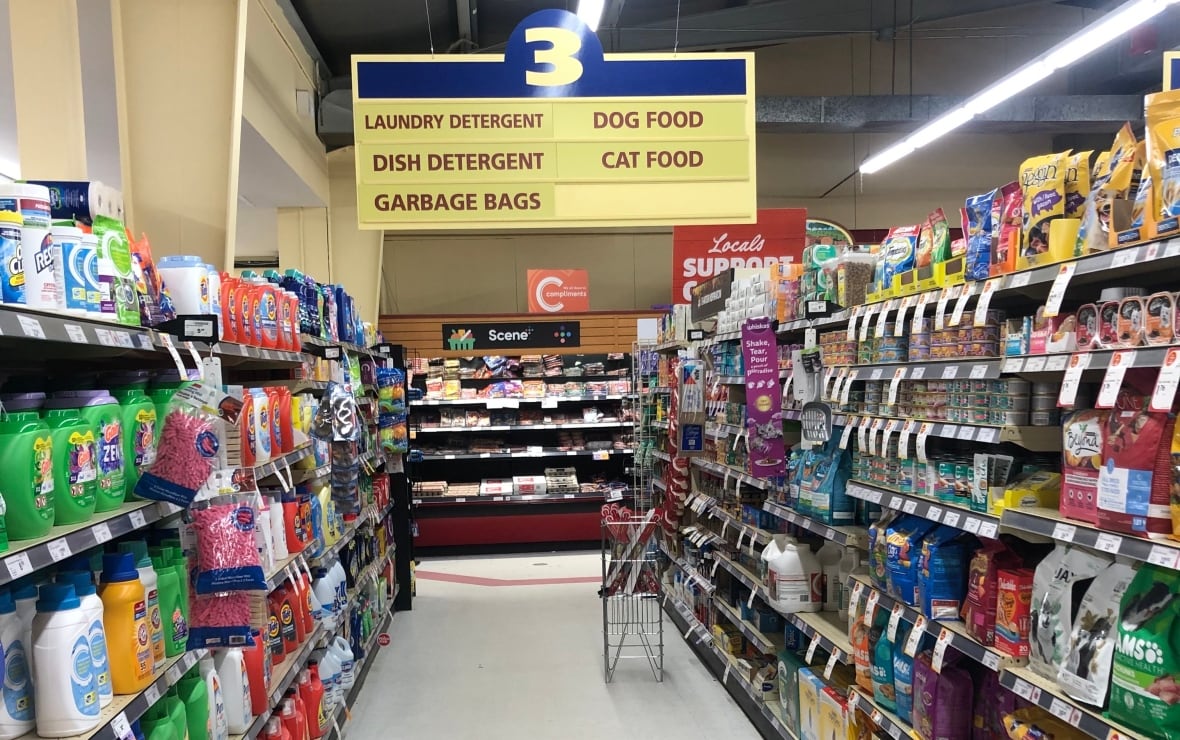 A grocery aisle with shelves of groceries on either side.