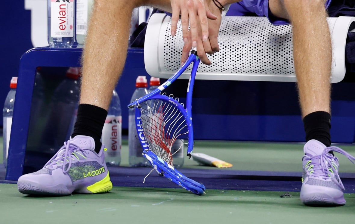 Two feet in tennis shoes and a broken striker