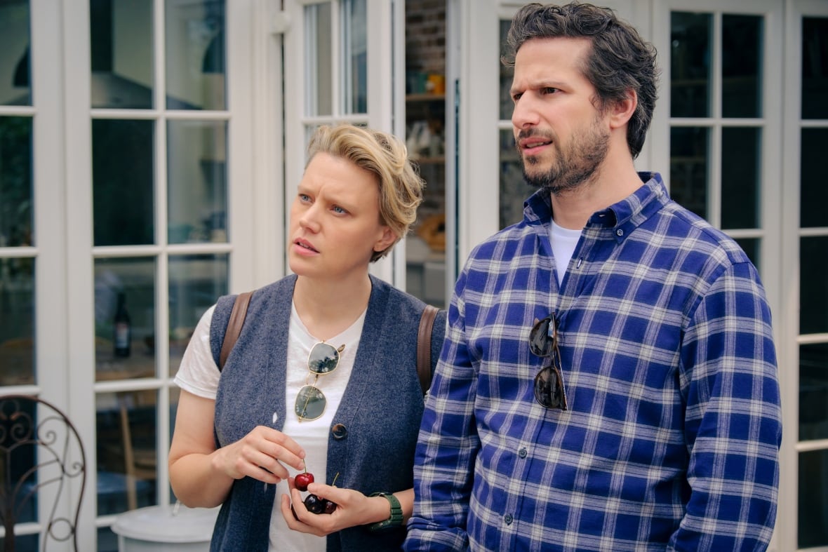 A worried looking man and woman stand outdoors. 
