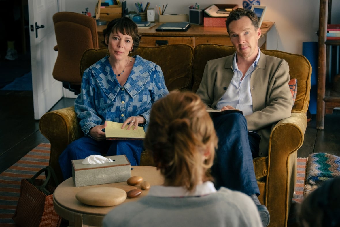 A man and woman sit in front of a woman.