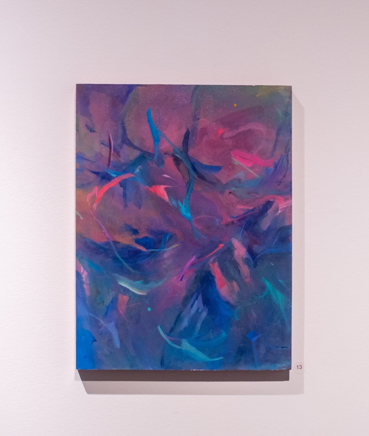 The abstract paintings shows a whirpool of colours, especially swirls of pinks and blues.