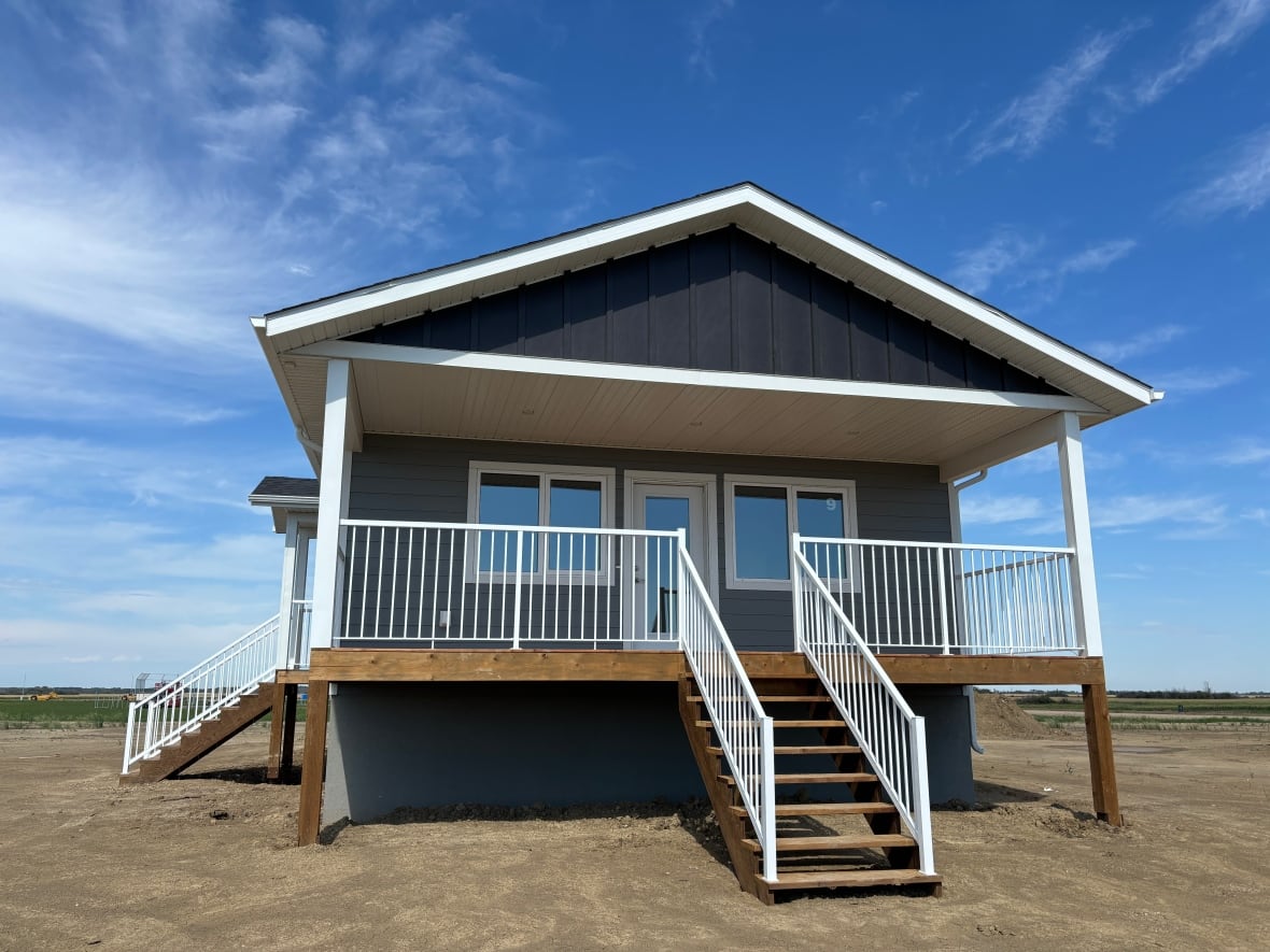 A home with a basement and raised first floor, with a front porch and staircase up to the door