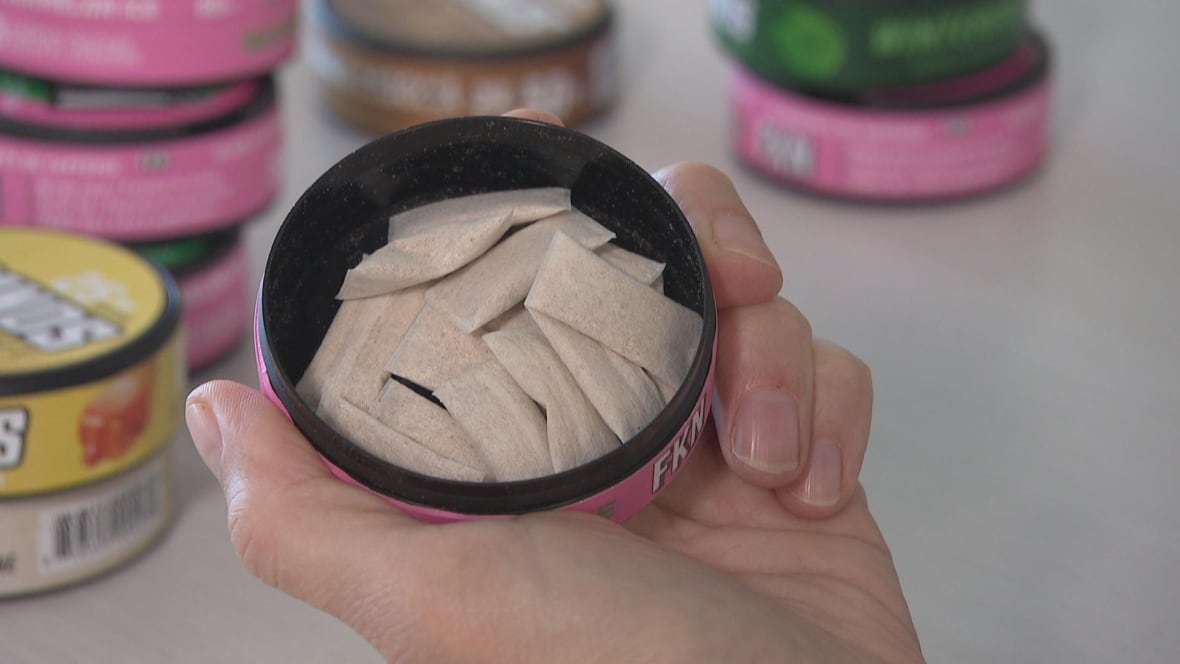 A tight shot of an open round container with caffeine pouches inside. There are stacks of other caffeine pouch containers inside.
