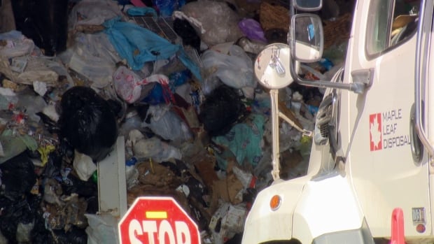 Solid waste is dropped off at a Metro Vancouver facility in Coquitlam in August 2025. Twenty-two per cent of waste arriving here, on average, is compostable organics, which were banned by Metro Vancouver in 2015. Piles of garbage, piled up inside a building.
