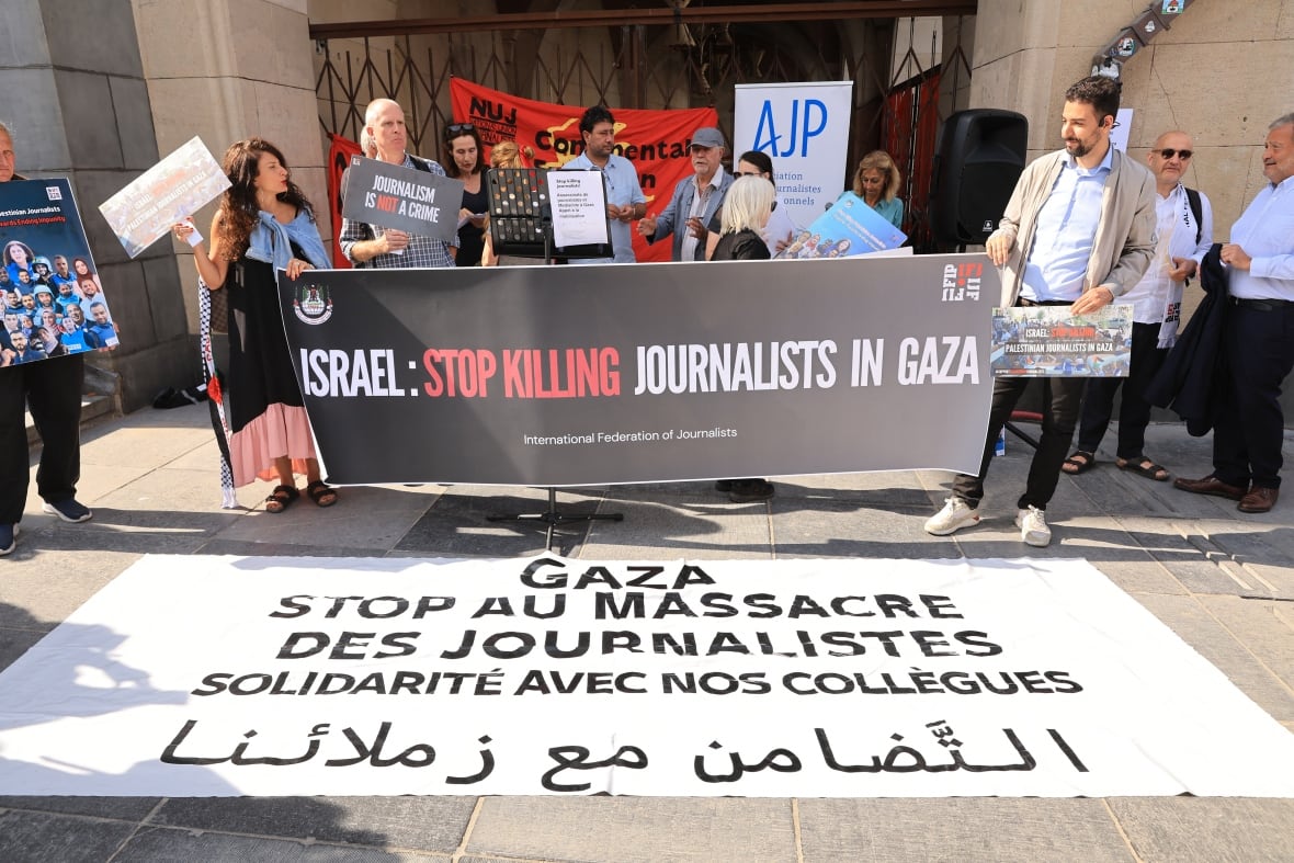 A group of people bearing a banner stipulating