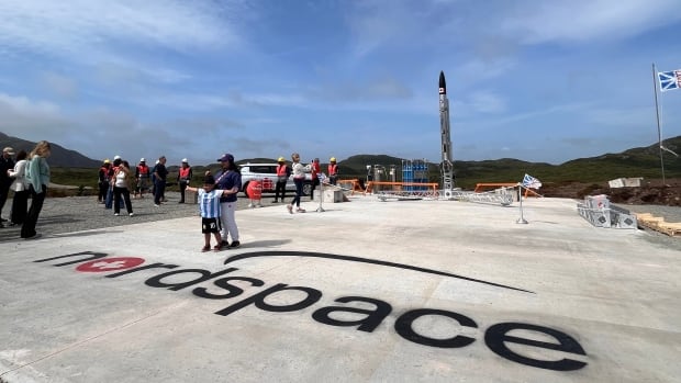 Tall rocket on concrete ground with words "nordspace."