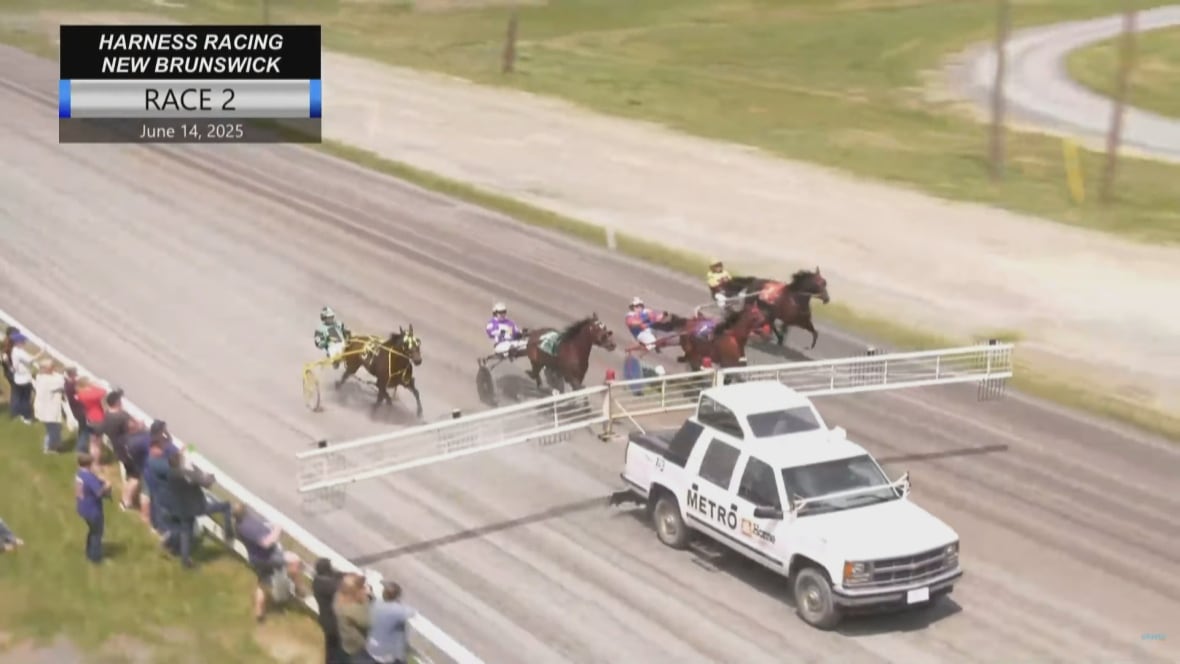 still frame taken from video shows starting truck with gates extended close to the spectators lined up against the wodoen fence.