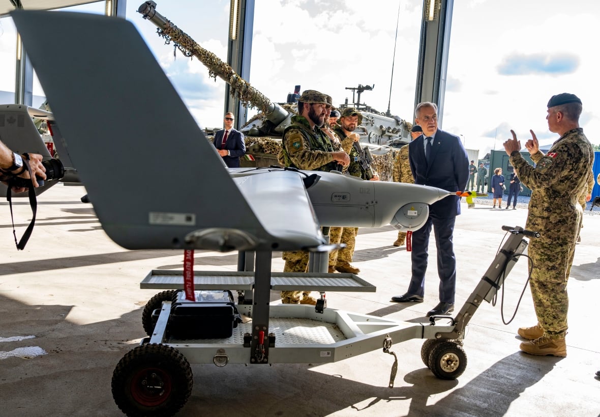Um drone pode ser visto em primeiro plano quando os membros militares andam em torno dele, com o primeiro -ministro Mark Carney.