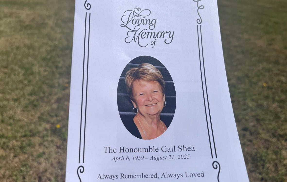 An oval photo of a smiling woman with short hair on a white paper with the words "In Loving Memory - Gail Shea."