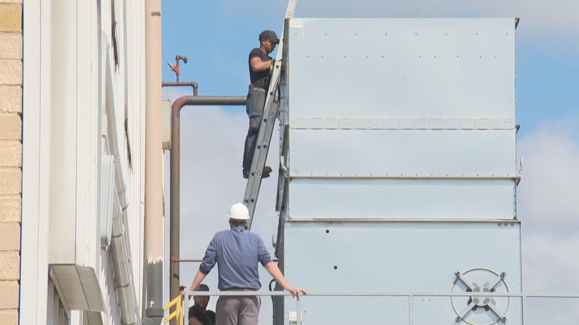 Workers clean a cooling tower at Sofina Foods in London, Ont., on Aug. 27, 2025.