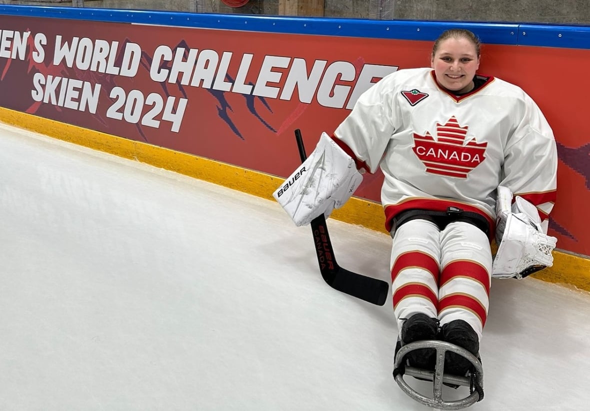 A smiling hockey goalie on a sled