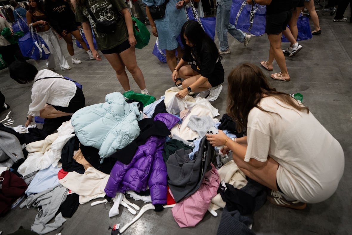 People go through a pile of clothing.